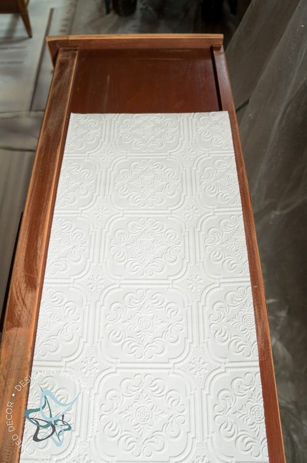 paintable wallpaper being used on a dresser side