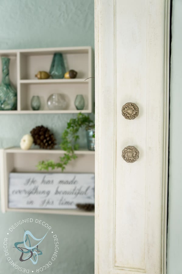 wall shelves decorated with fall foliage, pine cones and mini white pumpkins