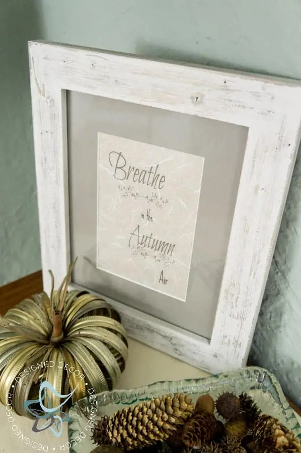 fall-decor-tablescape-centerpiece-easy-inexpensive-free-printable fall-vignette with a bowl of pine cones, a metal pumpkin, and fall quote in a picture frame