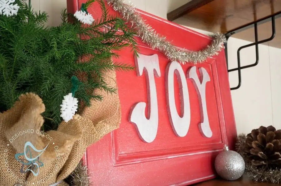 Come see how easy it is to make this Joy Holiday Sign- No power tools required! www.designeddecor.com repurposed-cabinet-door-joy-plaque-3