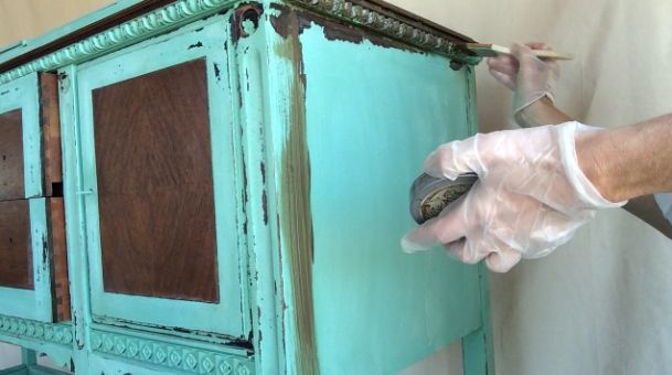 applying furniture glaze to a green painted buffet