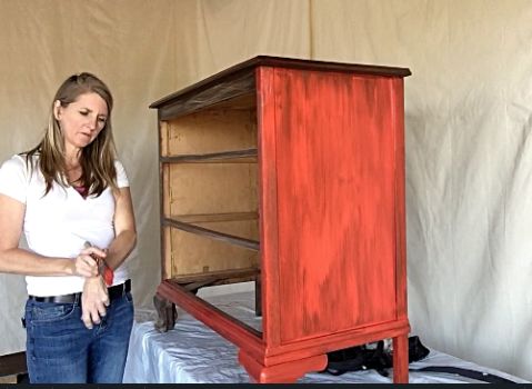 a dresser being hand painted with red chalk paint