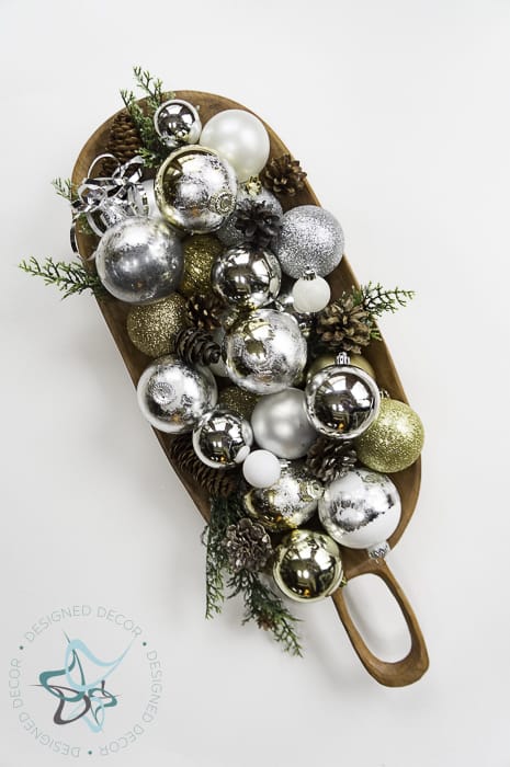 place ornaments in a bowl with pine cones and touches of green - Designed Decor