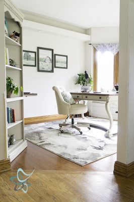 entryway view of a home office with desk and bay window 