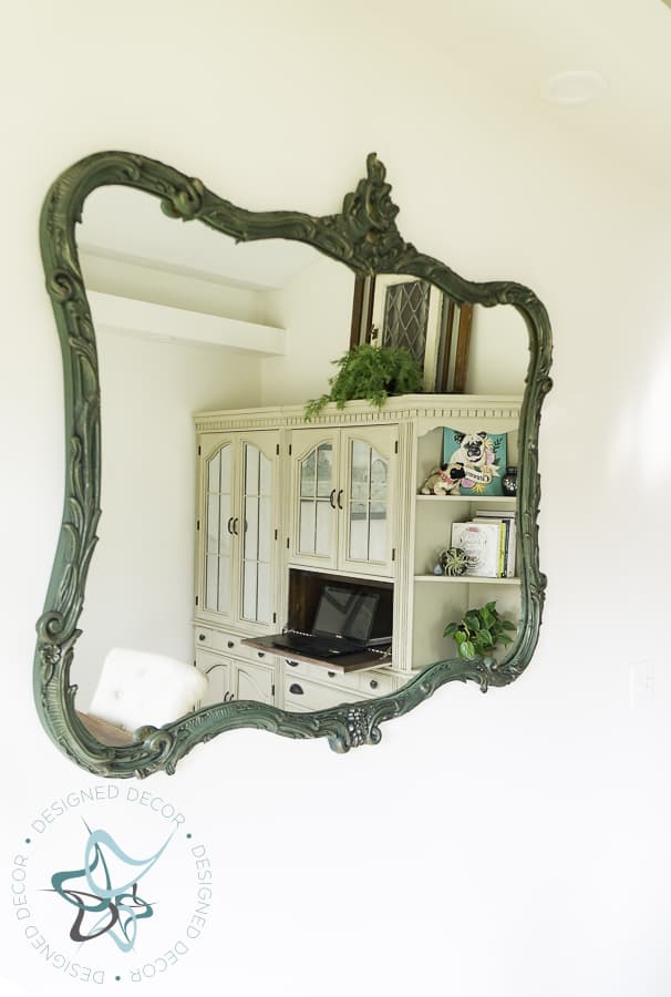 antique painted mirror with reflection of office shelves