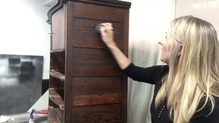 lady painting an antique oak dresser with a natural paint distresses look