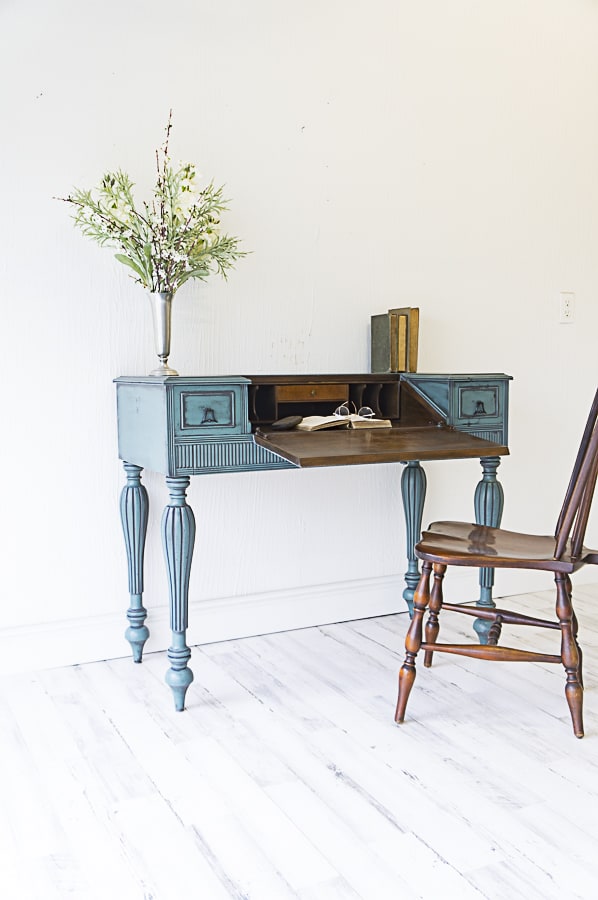 small secretary desk painted in blue with powder glazing details.