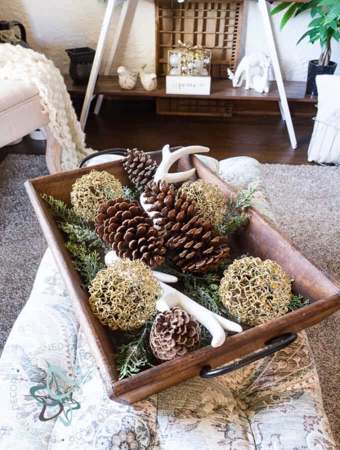 image of a serving tray with evergreens, pine cones, antlers and Christmas bulbs