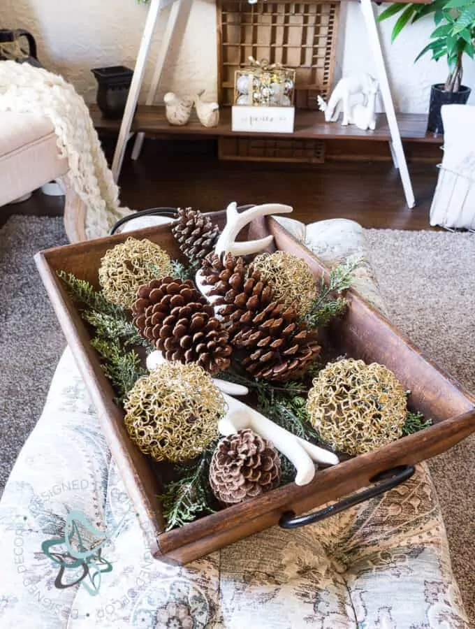 image of a serving tray with evergreens, pine cones, antlers and Christmas bulbs