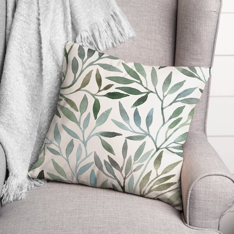 green leaves print pillow sitting on a chair