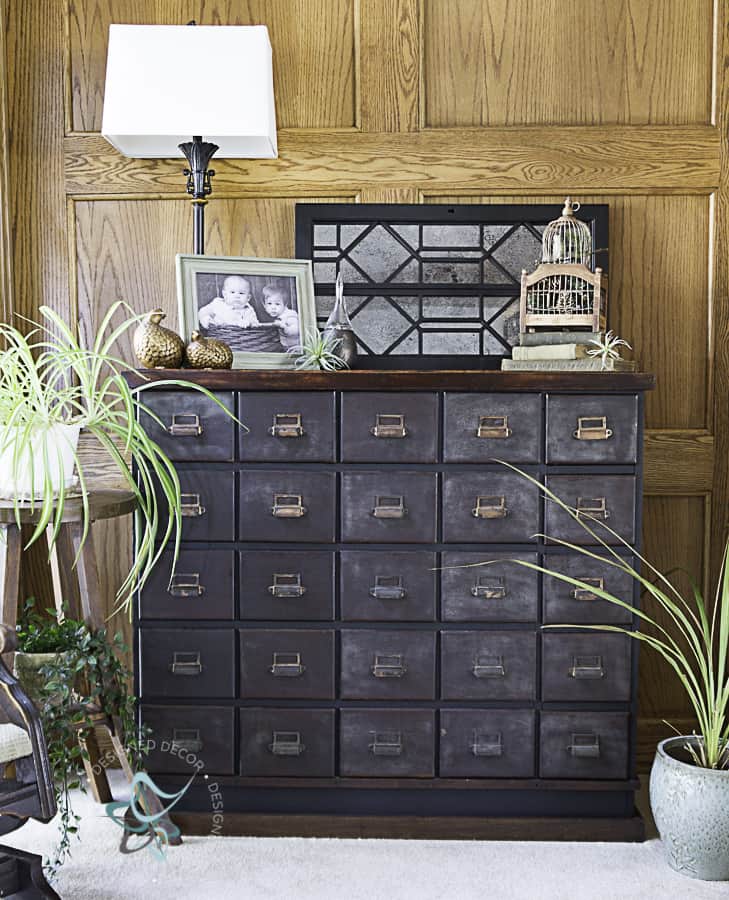 picture of an antique apothecary cabinet decorated with plants and home deocr accessories