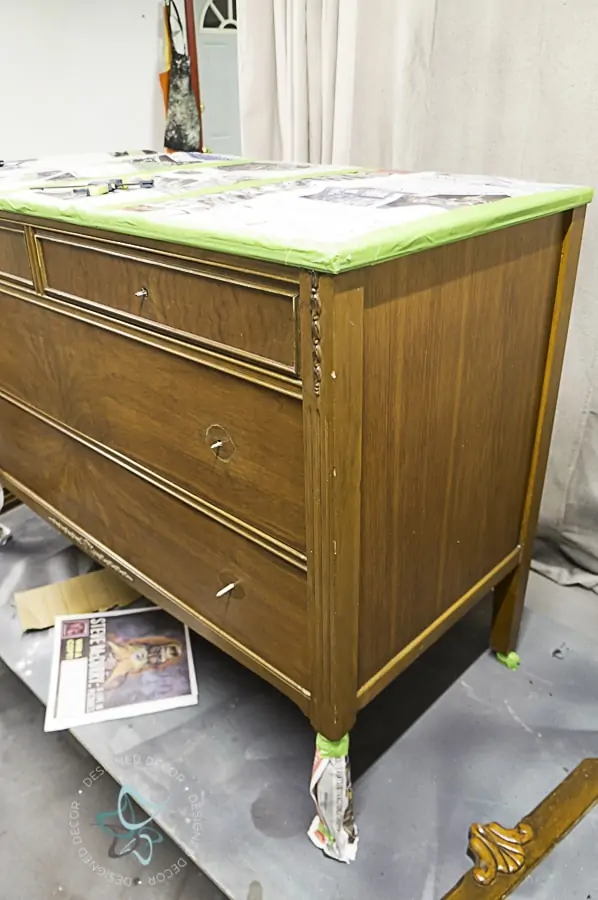 wood dresser before painting with a newspaper sealed top to prevent paint on the top