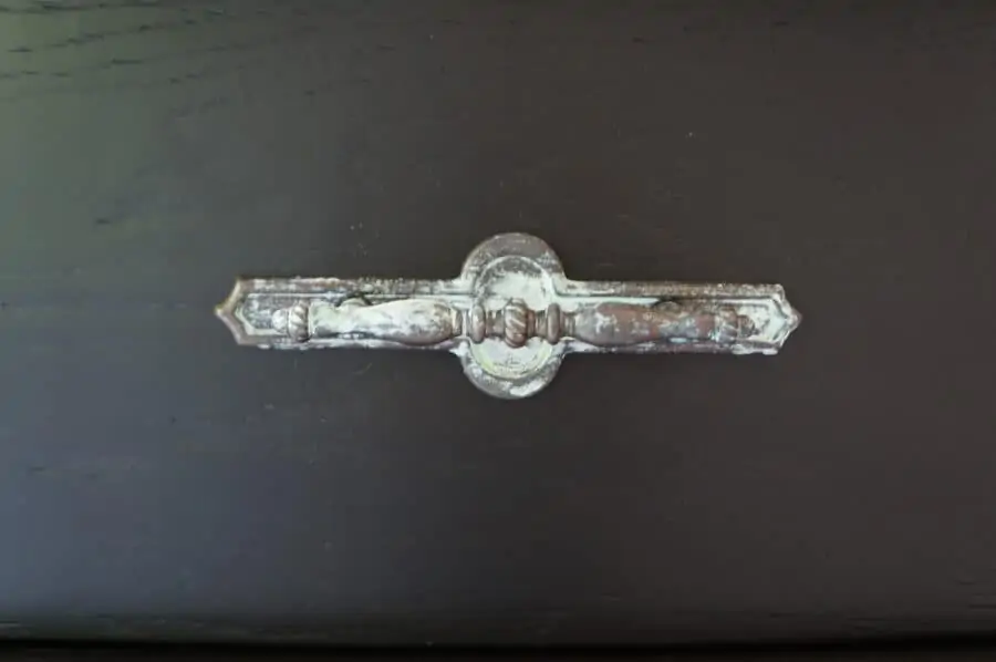 See how easy it is to create a patina effect on any type of surface. The black painted wine bar is the perfect contrast for the patina effects on the hardware, wine bottle holder and lead glass panel door. This furniture painting tutorial shows you how to create the patina effect with step by step instructions. #furniturepaintingtutorial