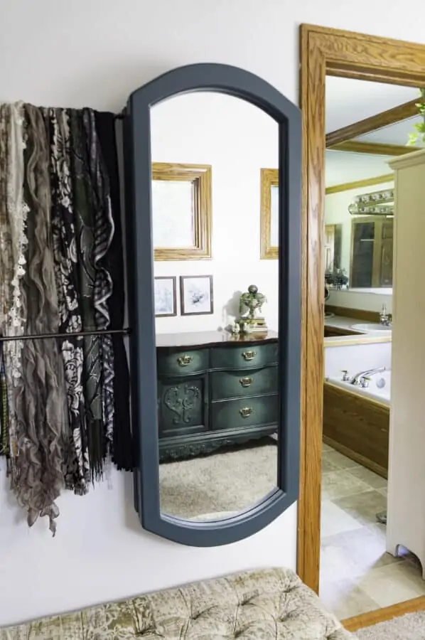 wall mounted mirrored jewelry cabinet with a reflection of a painted dresser