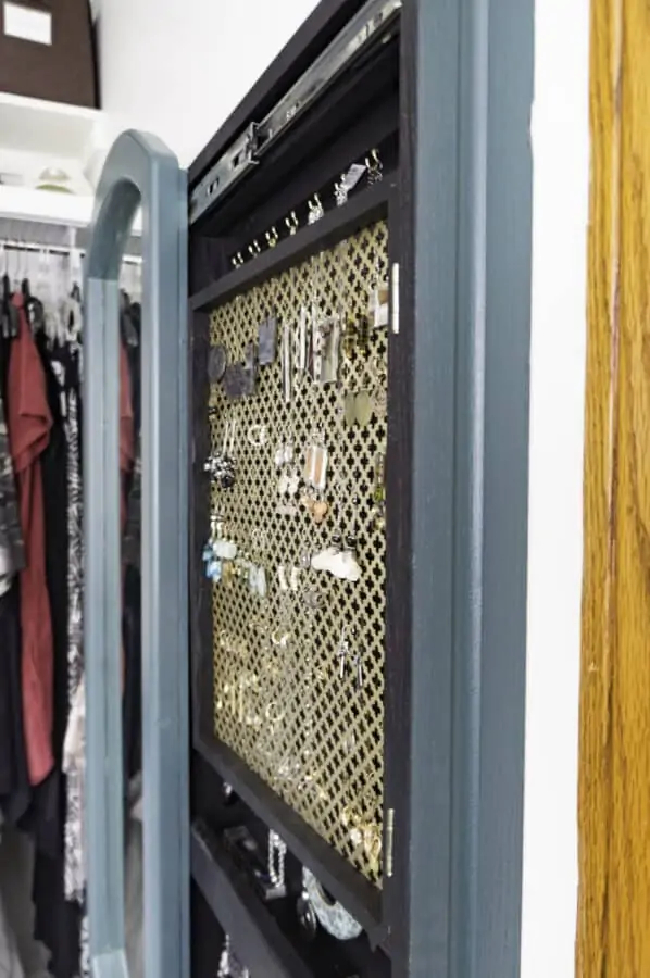 Close up of the framed gold decorative metal sheet with earrings hanging on it