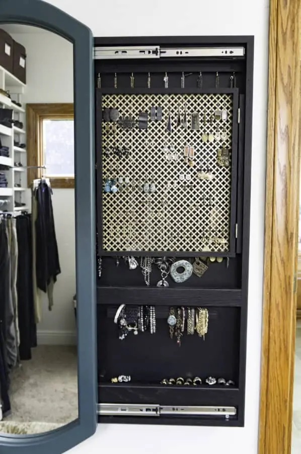 wall mounted sliding jewelry cabinet with the mirror open showing the jewelry inside