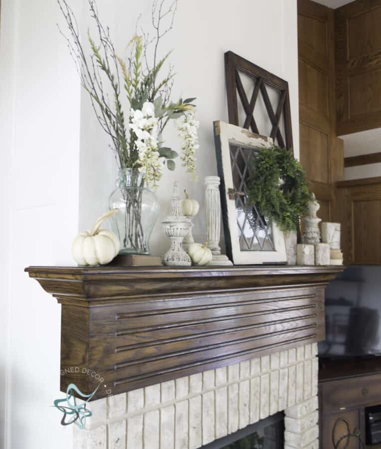 fireplace mantel with fall decor of windows, candlesticks, pumpkins and floral