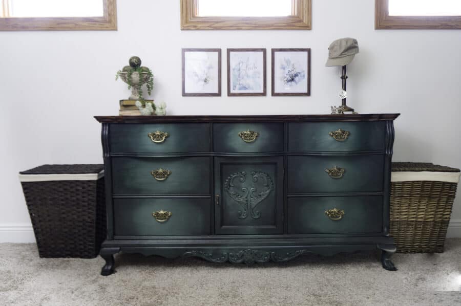 green painted dresser with decorative items sitting on top and laundry baskets beside the dresser