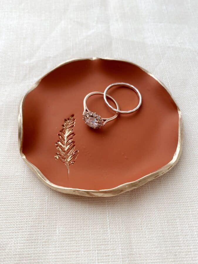 fern leaf stamped onto a clay dish with a ring sitting on the dish