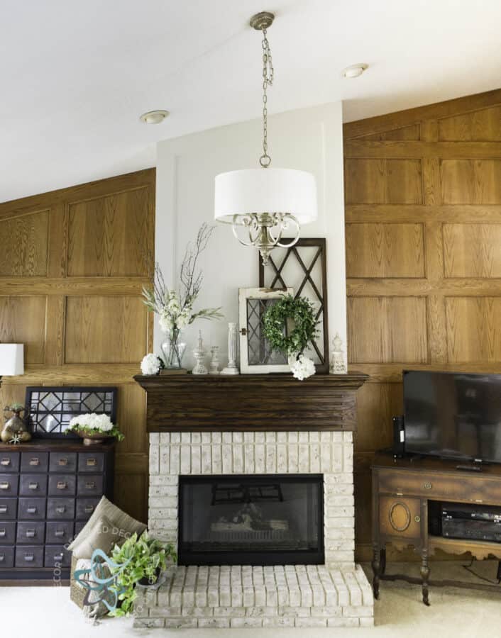 DIY drum shade chandelier handing above fireplace