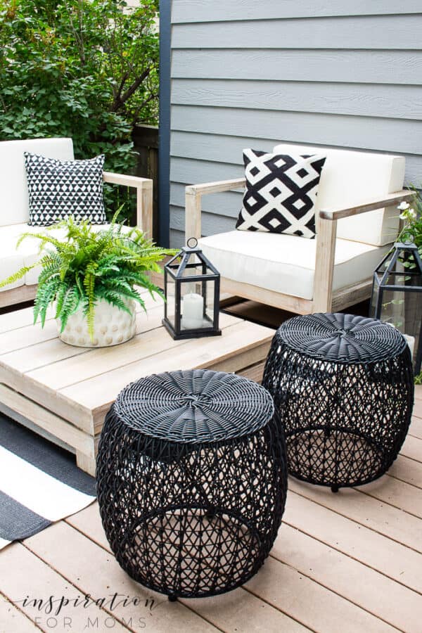 outdoor deck with wood patio furniture and black and white accessories