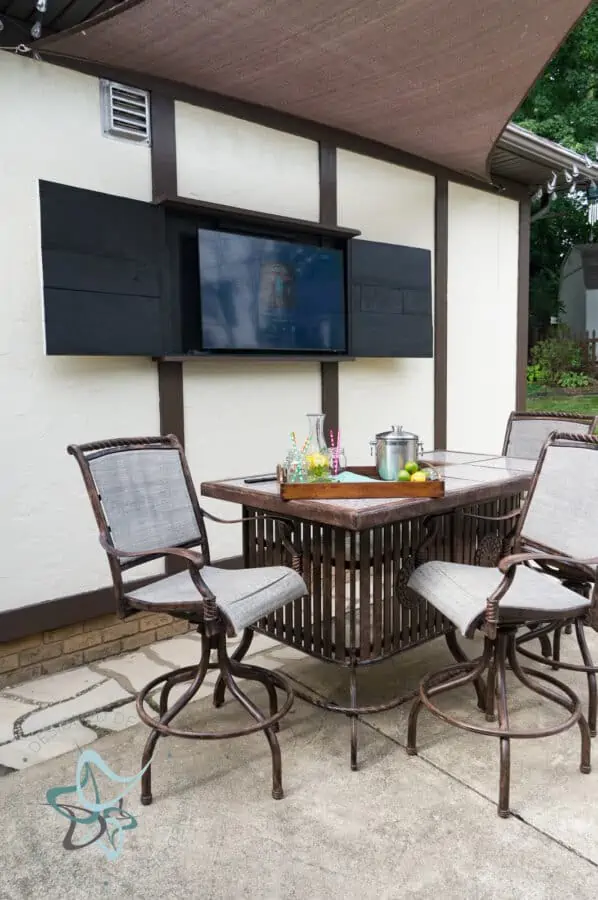 outdoor TV cabinet open above patio table set