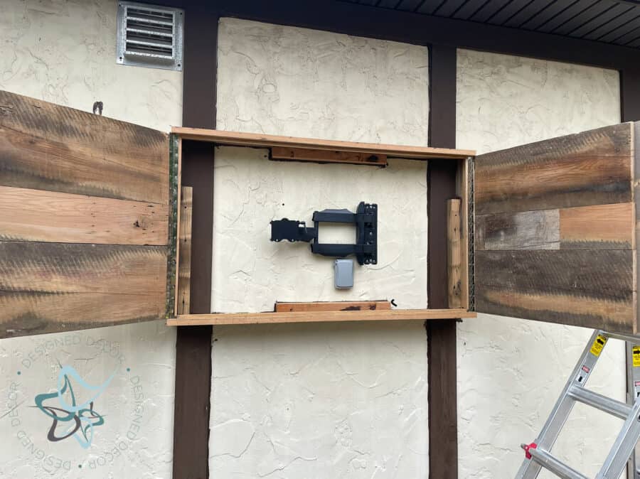 unfinished tv cabinet mounted on garage wall