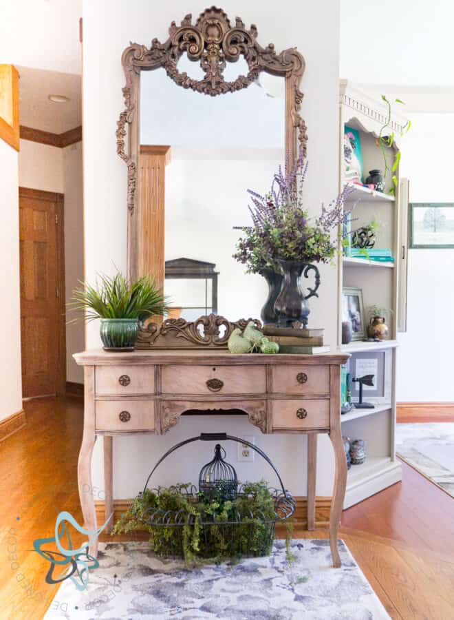 bleached wood entryway table decorated with vintage decor pieces