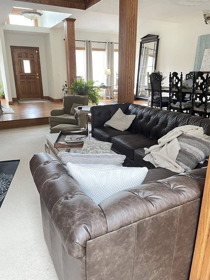 open concept living room with brown tufted leather sofa