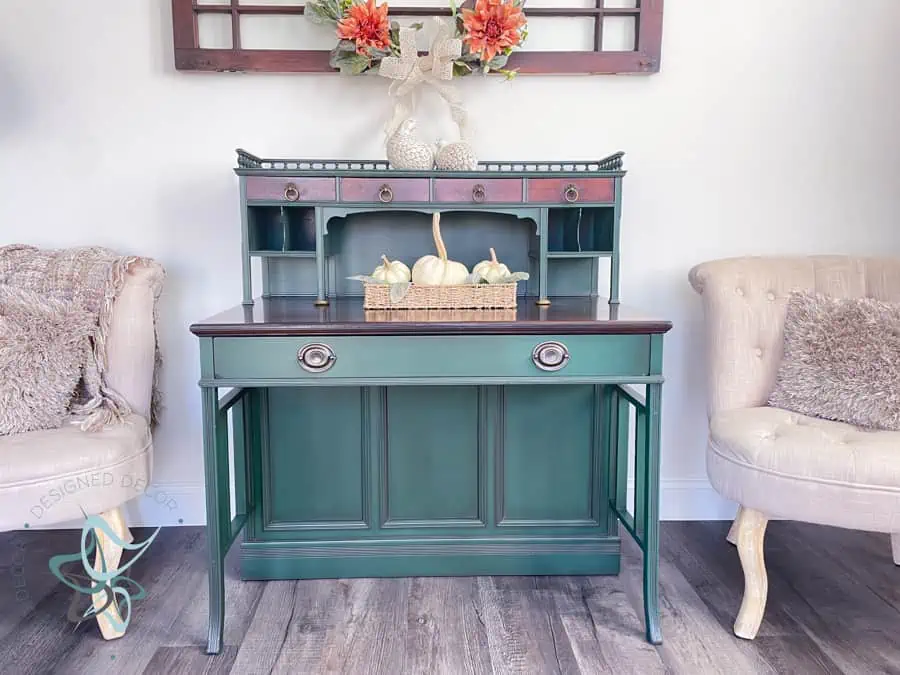 antique desk painted in a bold deep green paired with modern side chairs