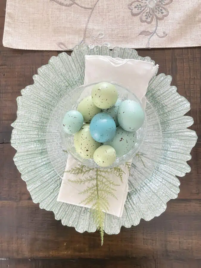 Spring table setting with green glass plate and bowl of faux robins eggs
